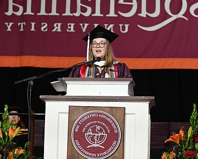 Kendra Kent '24 stands behind a podium at Commencement.